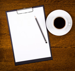 Clipboard with blank page and cup of coffee
