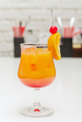 Alcoholic cocktail with a cherry on the table