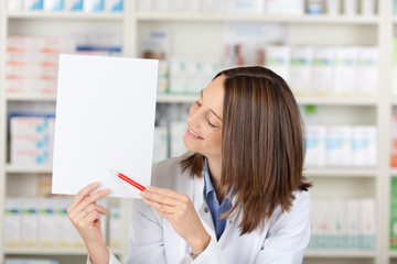lächelnde apothekerin zeigt weißes schild