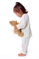 enfant en pijama parle a son ours en peluche
