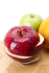mixed fruit emphasized red sliced apple with water drops.