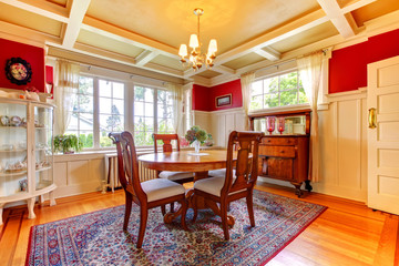 Elegant red and gold dining room with antique furniture.