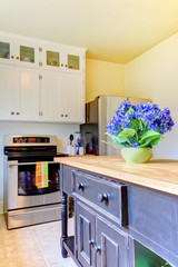 Kitchen with black island and white cabinets.