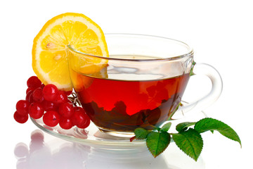 Black tea  with red viburnum and lemon in glass cup isolated