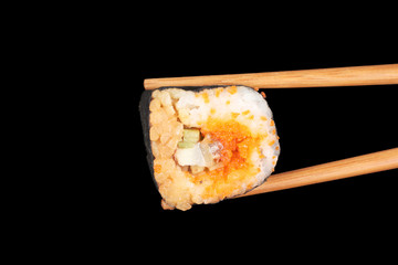 delicious sushi and chopsticks on black background
