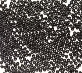 black pearls scattered on a white background