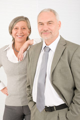 Senior businesspeople leaning over shoulder professional smile