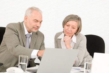 Senior businesspeople looking computer in office