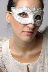 Young and beautiful girl in the mask and costume of an angel