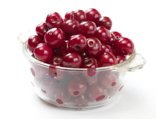 Bowl with ripe cherries. Isolated on a white background.