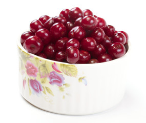 Bowl with ripe cherries. Isolated on a white background.