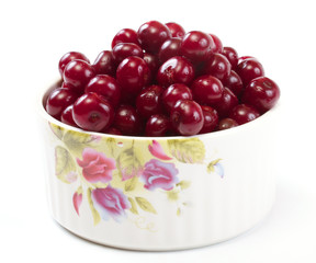 Bowl with ripe cherries. Isolated on a white background.