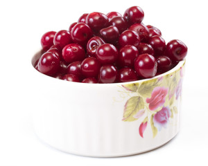 Bowl with ripe cherries. Isolated on a white background.