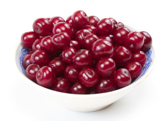 Bowl with ripe cherries. Isolated on a white background.