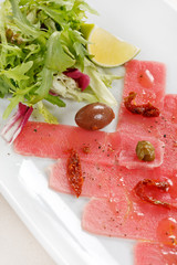 Fish Carpaccio with olives ana salad