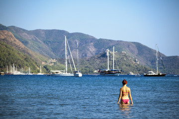 Fototapeta na wymiar Piękna młoda kobieta w morzu. Port w Marmaris - Turcja.