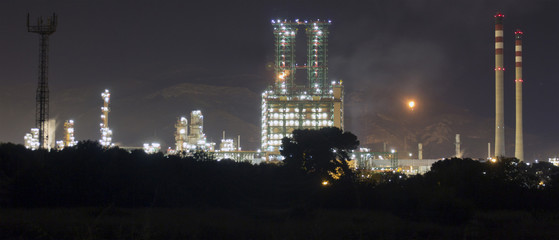 Fototapeta premium Petrochemical refinery at night with full moon light