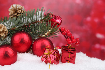 Christmas ball and green tree in the snow on red