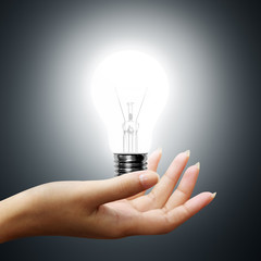 light bulb on business hands on gray background