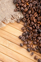 Coffee beans on wooden background with linen canvas