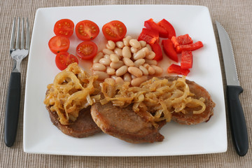 fried pork with onion, beans and salad