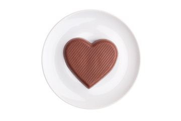 Flat chocolate heart on a saucer