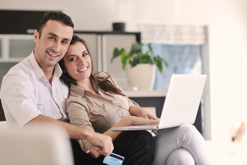 joyful couple relax and work on laptop computer at modern home