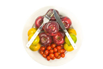 spoon and silverware on apple, orange, tomato