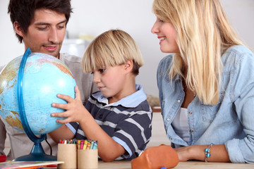 Fototapeta premium happy family looking terrestrial globe