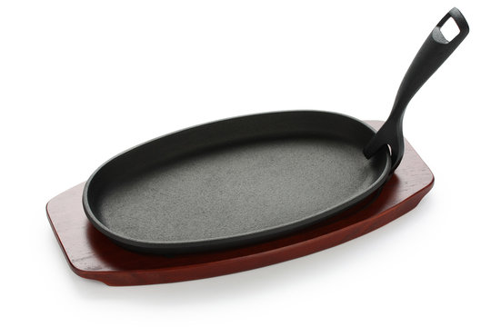cast iron sizzling steak plate on wooden base