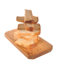Pieces of bread  lay on a wooden board