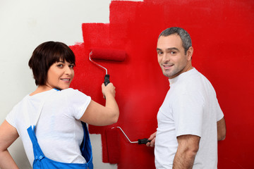 Married couple painting wall