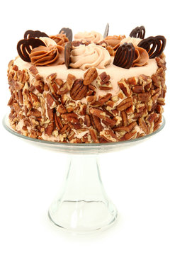 Decorated Pecan Caramel Chocolate Cake On Glass Display Platter