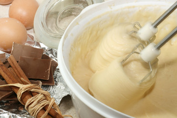 Cake ingredients in bowl with electric mixer next to it