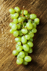 Wet green grapes on a wooden table