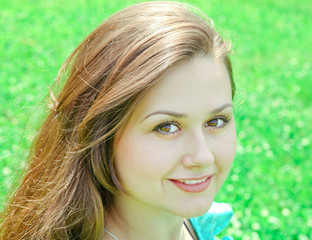 portrait of beautiful young woman relaxing in summer park