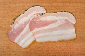 sliced?bacon on a wooden cutting board