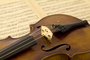 Vintage viola bridge with strings and sheet music