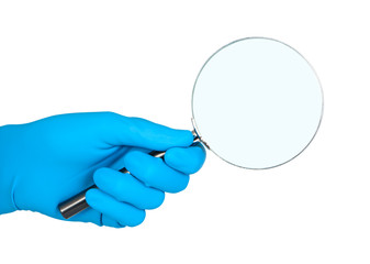 Hand in rubber glove holding magnifier.