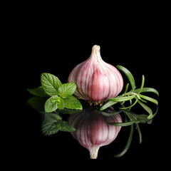 Garlic and herbs with reflection isolated on black