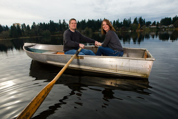 Happy couple on a romantic date in a rowboat