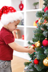 Little boy decorating Christmas tree