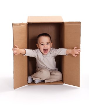Happy little boy in cardboard box