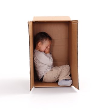 Sad Little Boy Hiding In Cardboard Box