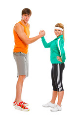 Fit girl and man in sportswear  shaking hands  isolated on white