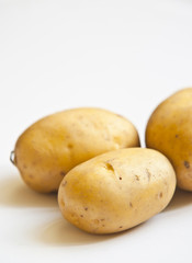 bunch of potatoes on white background close up shoot