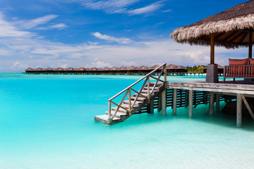 Over water bungalow with steps into blue lagoon