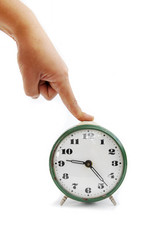 The female hand presses on the button of an old alarm clock