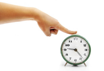 The female hand presses on the button of an old alarm clock