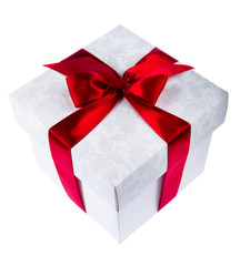 White gift box decorated with red ribbon on white background